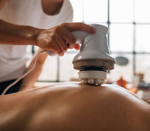 Een persoon die een massageapparaat gebruikt voor het herstel van vermoeide benen na een training.
